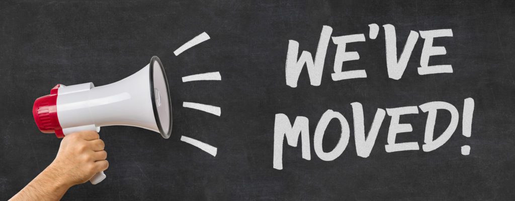 A chalkboard with the text WE'VE MOVED! booms from a megaphone, symbolizing an exciting business relocation notice.